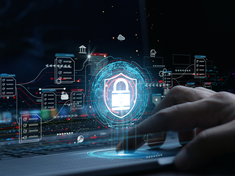 Digital security concept with a hand on a touchpad and a holographic security shield icon.