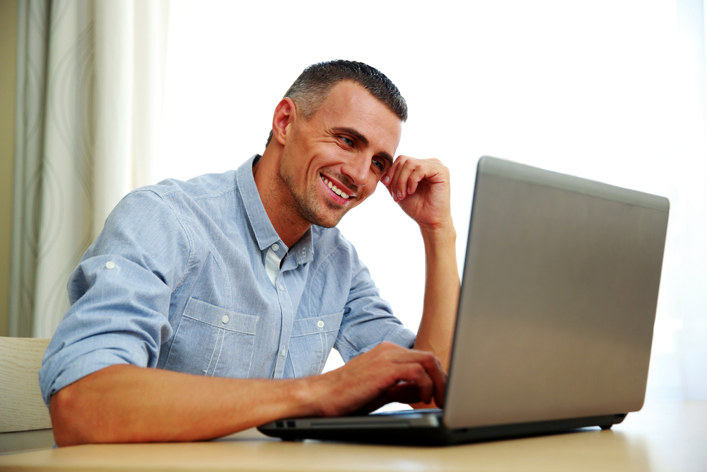 Smiling businessman working with laptop